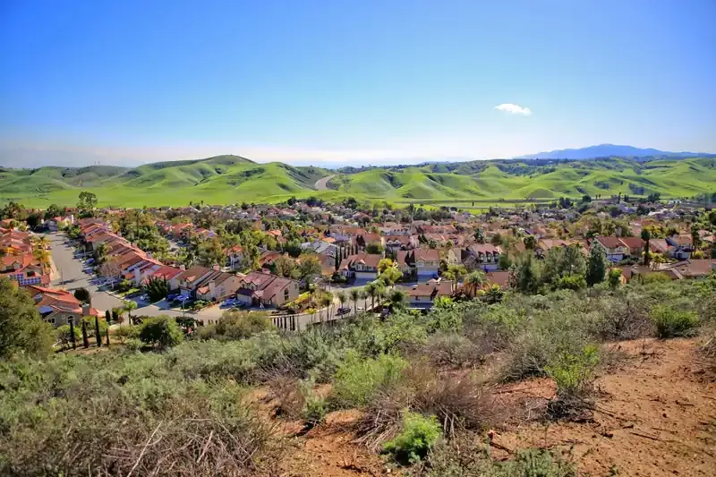Tile-roofed neighborhoods below green rolling hills in Diamond Bar