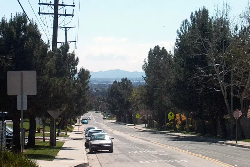 Street of 1980s single-story stucco homes with tile roofs in Moreno Valley